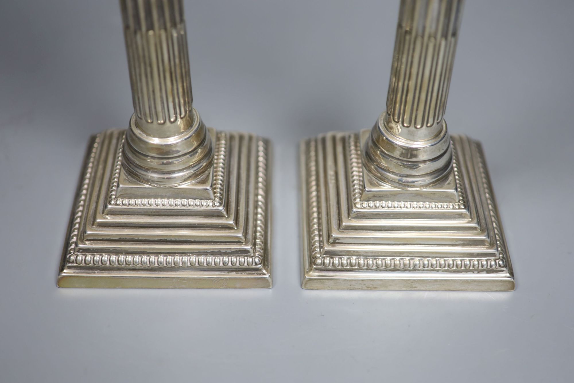 A pair of George VI silver corinthian column candlesticks, RS, London, 1950, height 26.8cm, 19oz.